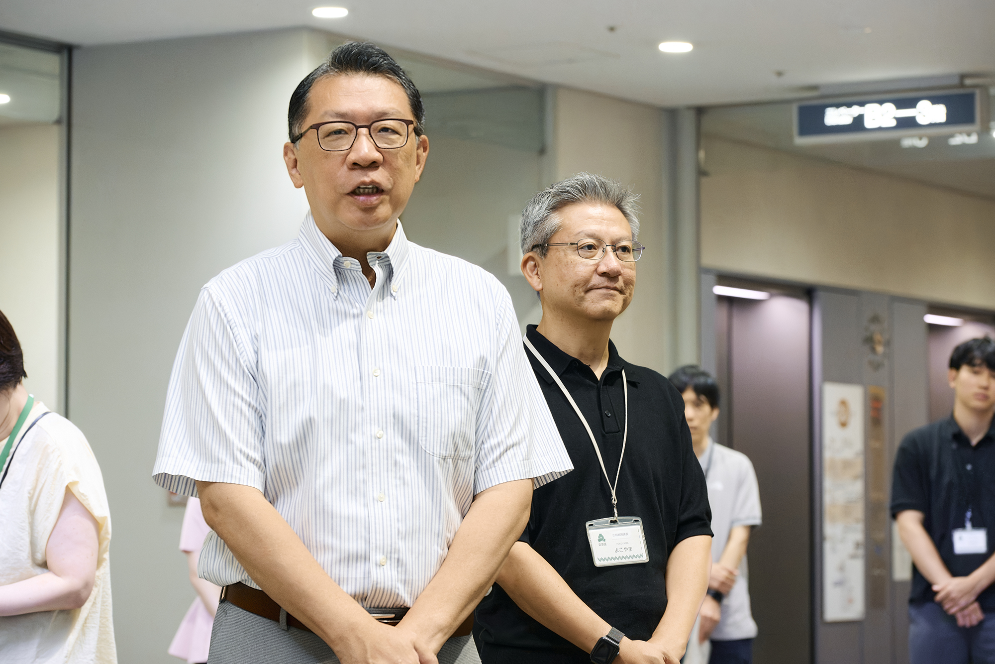成澤廣修文京区長（左）、横山尚人広報戦略課課長が激励に
